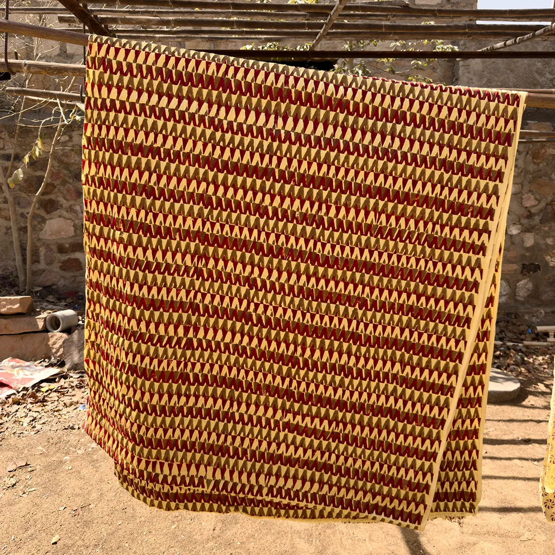 Hand-printed Ajrakh cloth drying in the sun between stages