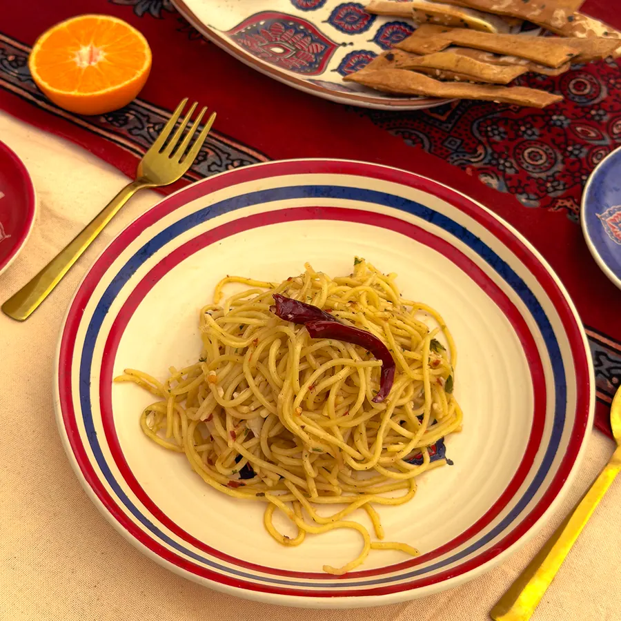 A meal served on a striped plate over an Ajrakh table runner